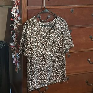 A cute floral top with brown and white flowers with a black base